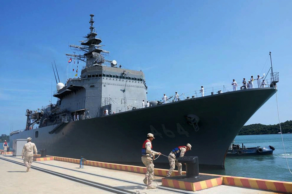 This handout photo taken and released on April 19, 2025 by the Embassy of Japan in Cambodia shows Royal Cambodian Navy personnel (foreground) securing the Japan Maritime Self-Defense Force (JMSDF) mine countermeasures vessel JS Bungo during docking at the Ream Naval Base. (Photo by Handout / Embassy of Japan in Cambodia / AFP) 