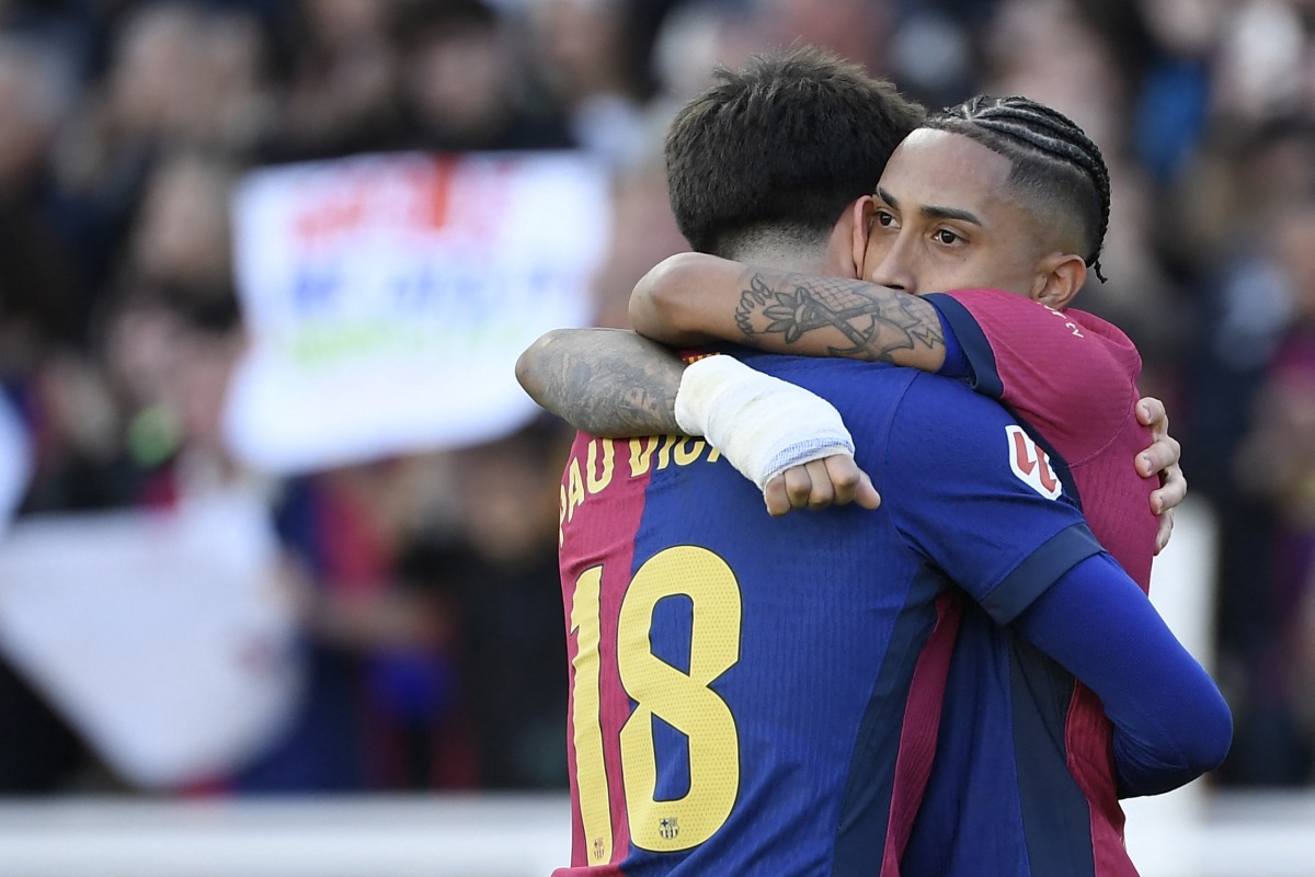 Barcelona's Brazilian forward #11 Raphinha celebrates with Barcelona's Spanish forward #18 Pau Victor Delgado after scoring his team's fourth goal during the Spanish league football match between FC Barcelona and RC Celta de Vigo at the Estadi Olimpic Lluis Companys in Barcelona on April 19, 2025. (Photo by Josep LAGO / AFP)
