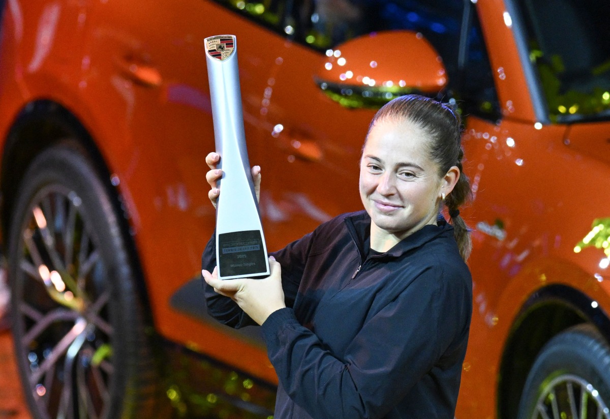 Latvia’s Jelena Ostapenko celebrates with the trophy in front of the winner's car after winning the final match against Belarus’ Aryna Sabalenka (unseen) at the Women's Tennis Grand Prix WTA tournament in Stuttgart, southwestern Germany, on April 21, 2025. (Photo by THOMAS KIENZLE / AFP)