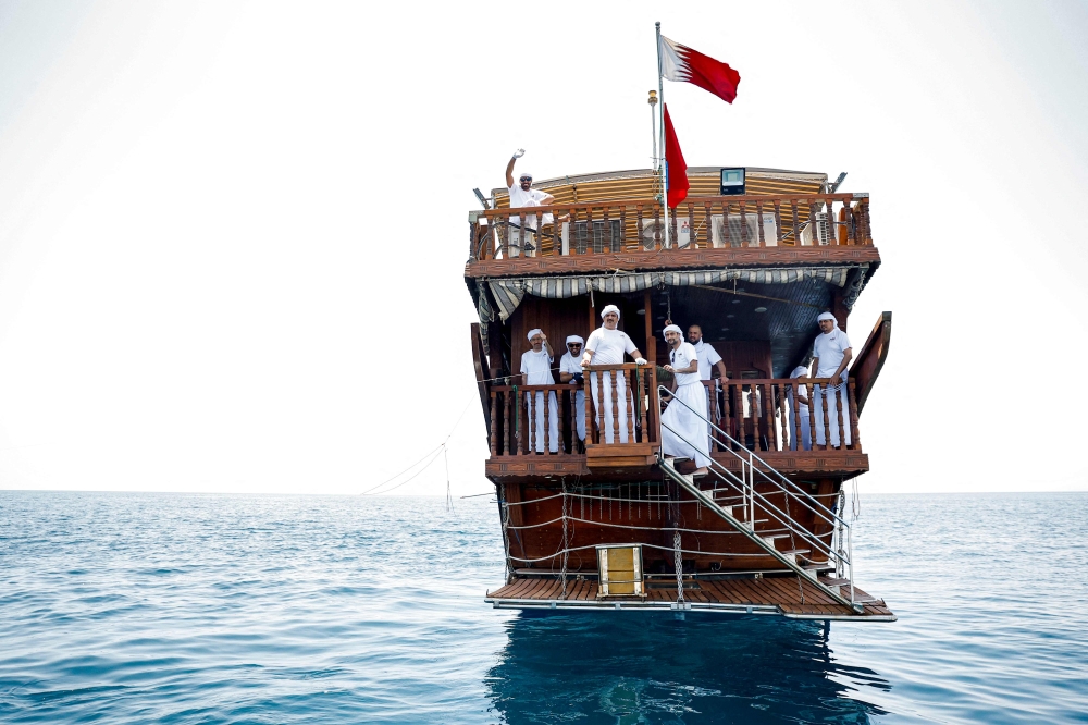 Participants aboard a traditional dhow boat during the hand-line fishing competition of the Senyar Festival off of Sealine south of Doha on April 21, 2025. (Photo by Karim Jaafar / AFP)