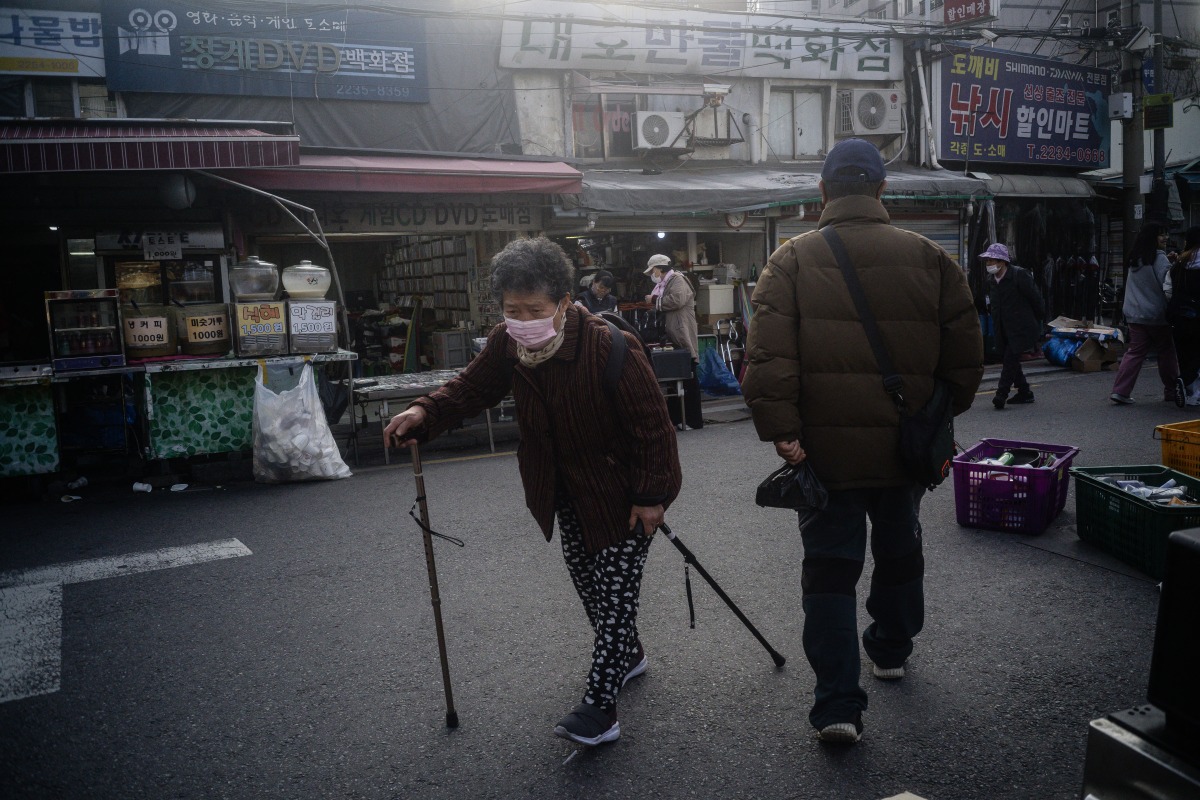 An elderly woman walks in the Dongmyo Flea Market in Seoul on April 15, 2025. (Photo by ANTHONY WALLACE / AFP)
