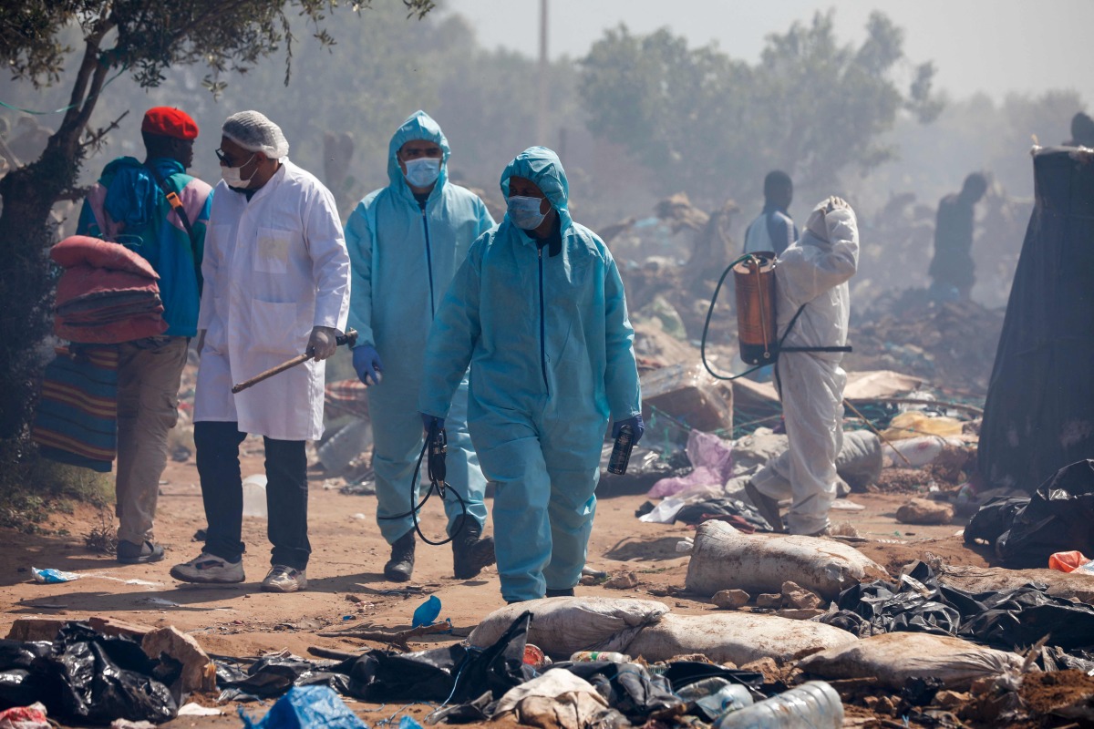 Members of Tunisian security forces dispense disinfectants as they dismantle a makeshift camp for migrants from sub-Saharan Africa at Ben Farhat farm near the Tunisian city of Sfax on April 24, 2025. (Photo by Mohamed KHALIL / AFP)