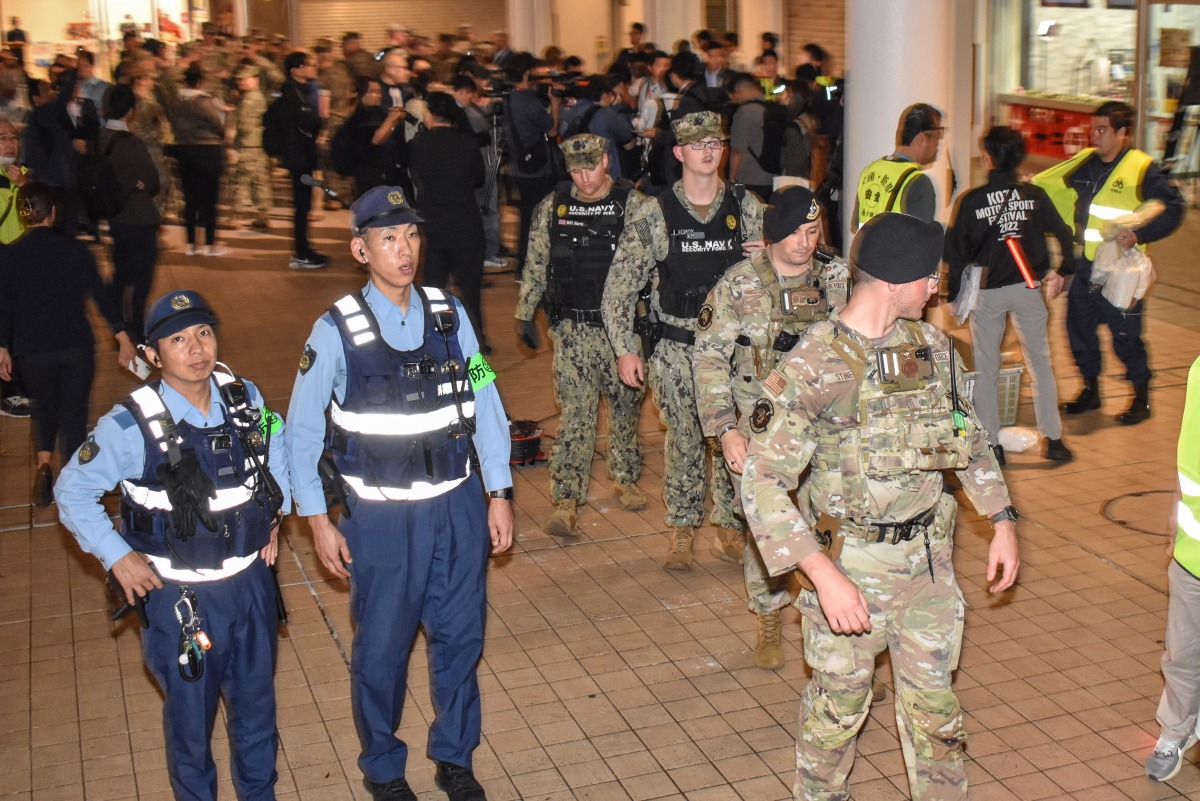 US miliary personnel join Japanese officials and residents for a one-off joint nighttime patrol on the streets of Okinawa City, Okinawa prefecture late on April 18, 2025, in the first such joint operation since 1973, following sexual assault cases involving US servicemen. (Photo by Hiroaki YAMASHIRO / AFP)
