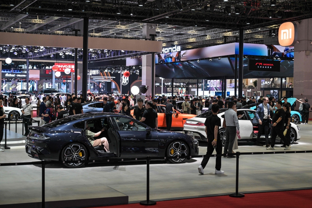 People visit the 21st Shanghai International Automobile Industry Exhibition at the National Exhibition and Convention Center in Shanghai on April 24, 2025. (Photo by Hector RETAMAL / AFP)
