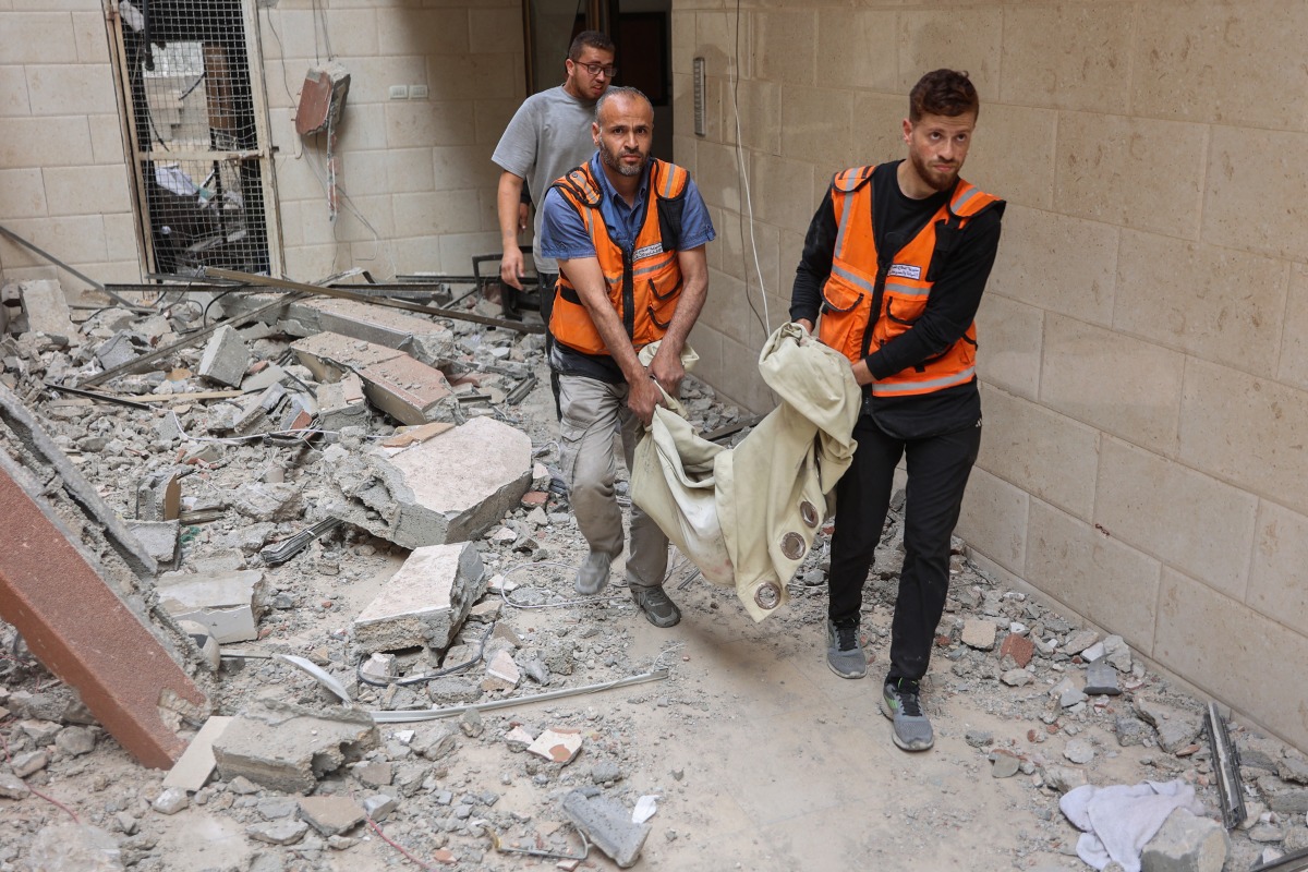 Palestinian medics transport the body of a victim following Israeli strikes which hit apartments in a residential building in Gaza City's Yarmuk street on April 24, 2025. Photo by Omar Al-Qattaa / AFP