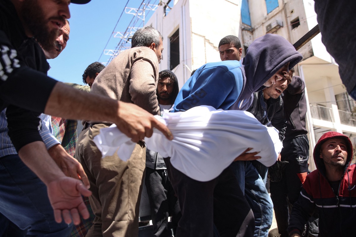 People carry the body of a member of the Al-Khour family in front of the Al-Shifa hospital after their house was hit by an Israeli strike in Gaza City's Sabra neighbourhood on April 26, 2025. (Photo by Omar AL-QATTAA / AFP)
