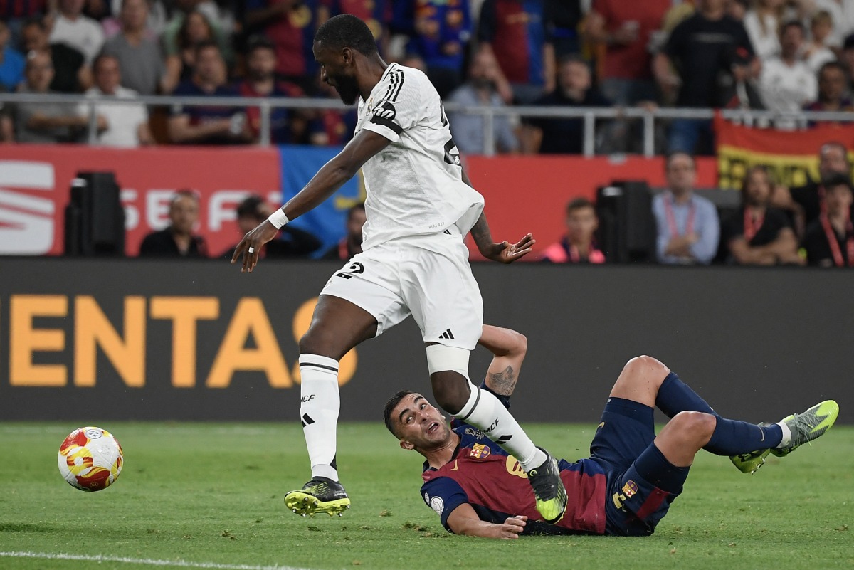 Real Madrid's German defender #22 Antonio Ruediger (L) and Barcelona's Spanish forward #07 Ferran Torres fight for the ball during their Spanish Cup, Copa del Rey (King's Cup) final football match between FC Barcelona and Real Madrid CF at La Cartuja stadium in Seville on April 26, 2025. (Photo by Josep LAGO / AFP)