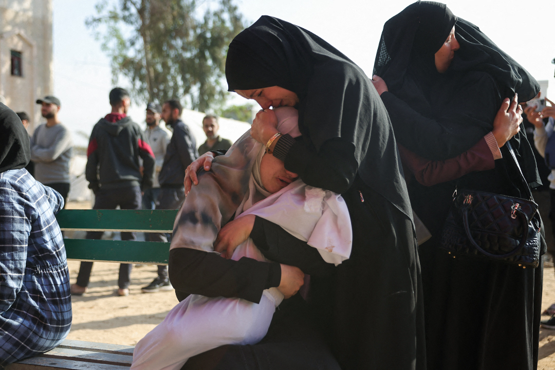 A Palestinian woman comforts another holding the body of her baby, killed in Israeli strikes on the the Abou Mahadi family home in Beit Lahia, outside the Indonesian Hospital in the northern Gaza Strip on APril 28, 2025. (Photo by BASHAR TALEB / AFP)
