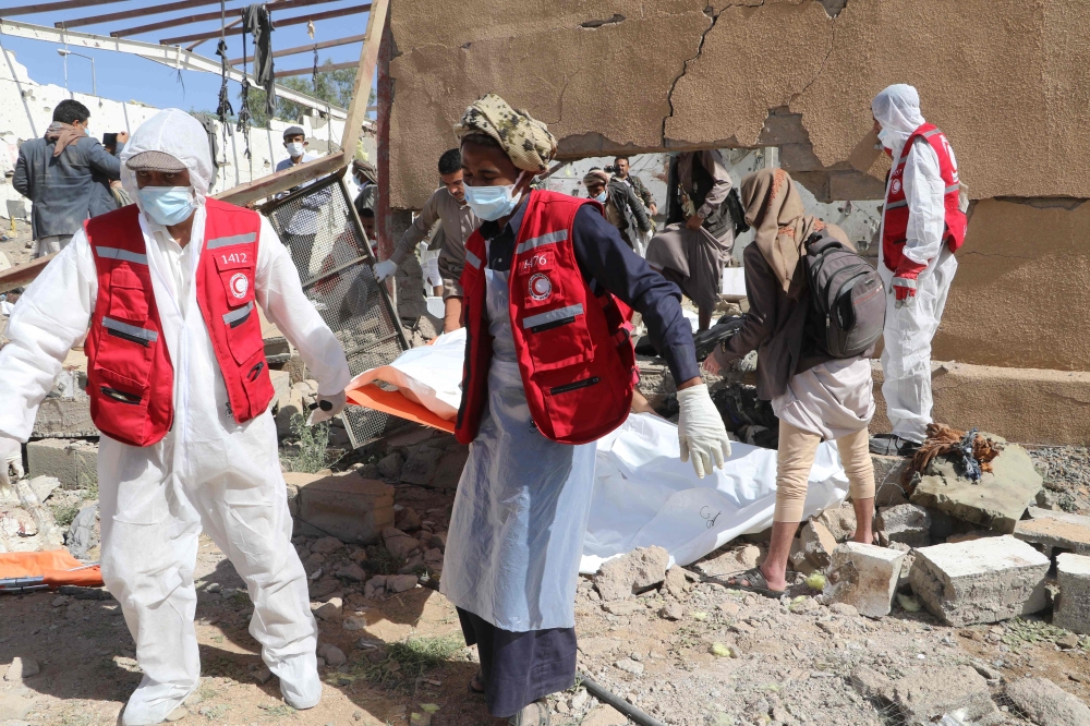 Yemeni rescuers transport the body of a victim from the rubble of a building hit in US strikes in the northern province of Saada on April 28, 2025. (Photo by AFP)