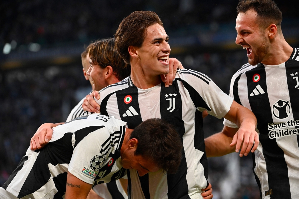 Juventus' Turkish forward #10 Kenan Yildiz (centre) celebrates scoring his team's first goal during the UEFA Champions League 1st round day 1 football match between Juventus FC and PSV Eindhoven, at the Juventus Stadium in Turin on September 17, 2024. (Photo by Isabella Bonotto / AFP)

