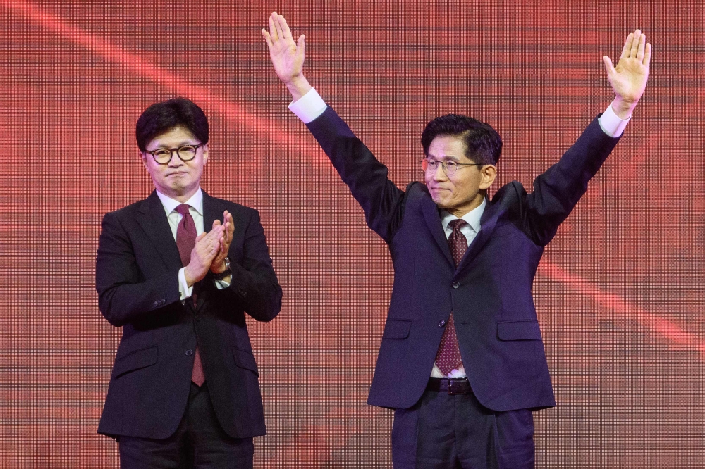 Former labour minister Kim Moon-soo (R) celebrates next to ex-party chief Han Dong-hoon after winning the final race to choose South Korea's conservative People Power Party's (PPP) candidate on May 3, 2025. (Photo by Anthony Wallace / AFP)