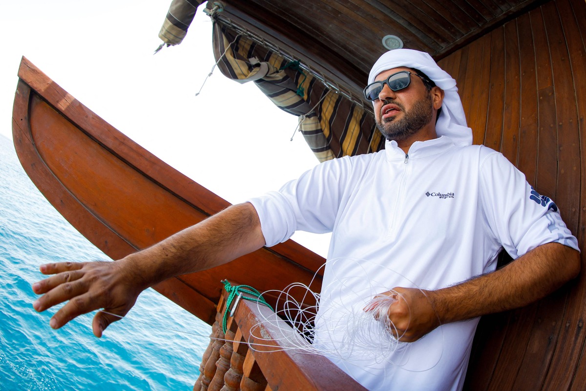 A competitor participates in a line-fishing competition aboard a wooden dhow during the Senyar festival off the coast of Sealine beach, south of Doha on April 21, 2025. Photo by Karim JAAFAR / AFP