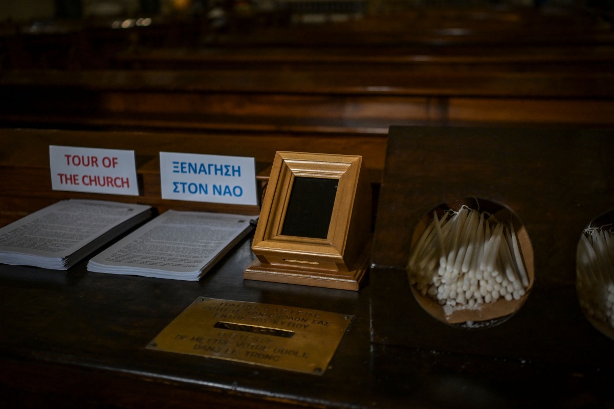 A Point of Sale (POS) device (C) is pictured at the Catholic Church of St Dionysius the Areopagite in Athens on May 4, 2025. Photo by Aris MESSINIS / AFP