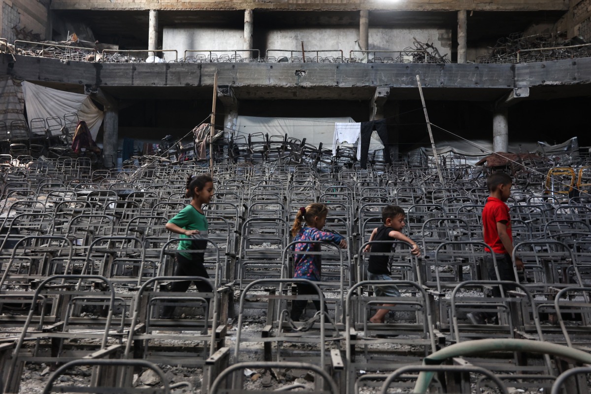 Displaced Palestinian children play at a damaged lecture hall at the Islamic University campus in Gaza City on May 1, 2025. Photo by Omar AL-QATTAA / AFP