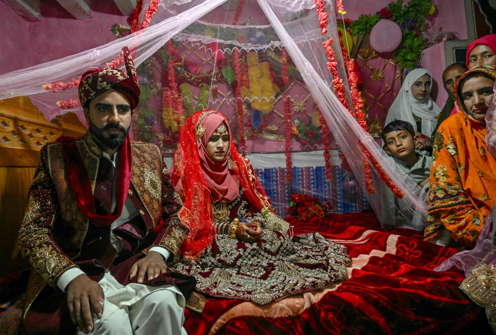 Groom Chaudhry Junaid with his bride, Rabia Bibi, during their wedding ceremony in Ashkot village on the Line of Control (LoC) in Neelum Valley, district of Pakistan-administered Kashmir, on May 3, 2025. (Photo by Farooq Naeem / AFP)