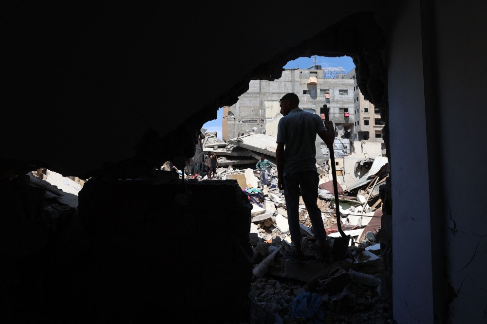 A Palestinian inspects the damage following overnight Israeli strikes, at the Nuseirat refugee camp in the central Gaza Strip on May 4, 2025.  (Photo by Eyad Baba / AFP)