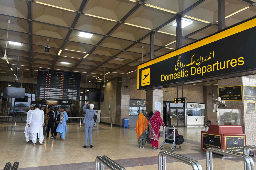 Passengers wait at Jinnah International airport after all domestic and international flights were cancelled in Karachi on May 7, 2025. (Photo by Asif Hassan / AFP)