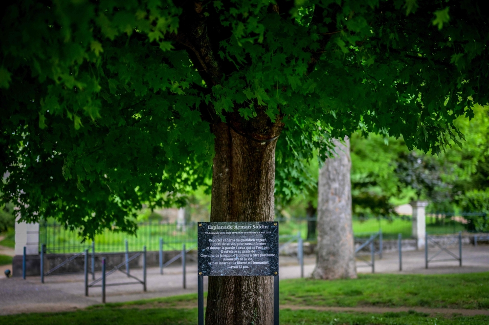 A photo shows a commemorative plaque in tribute to AFP cameraman Arman Soldin killed in Ukraine, on the esplanade of the University Centre in Vichy, central France, on May 7, 2025. (Photo by Olivier Chassignole / AFP)