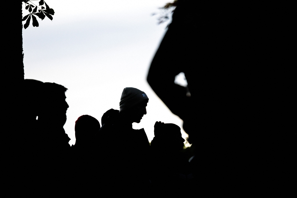 File photo: Silhouettes of migrants. (Photo by Jens Schlueter / AFP)