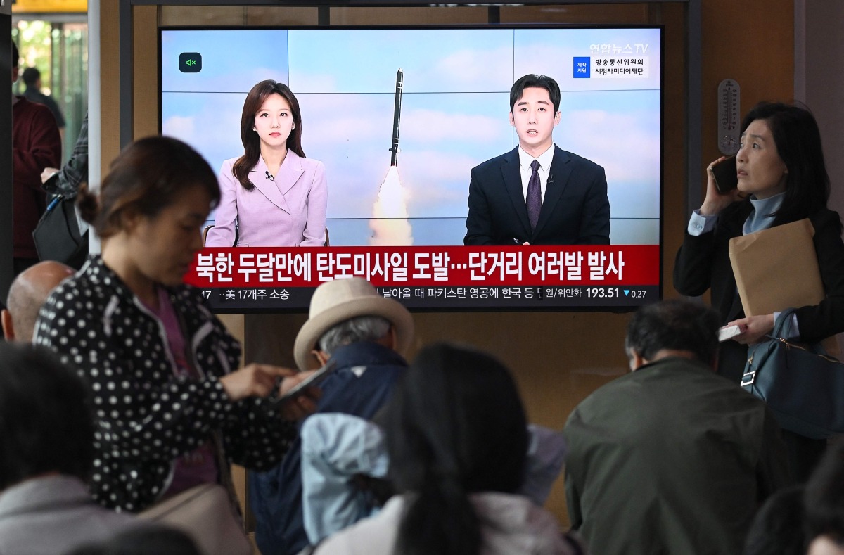 People watch a television screen showing a news broadcast with file footage of a North Korean missile test, at a train station in Seoul, yesterday. (AFP)