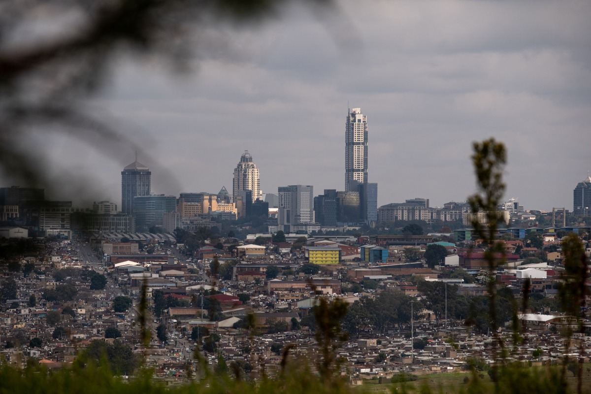 A general view of the Alexandra township with the Sandton cityscape in the background taken from Linbro Park in Johannesburg on May 4, 2025. (Photo by EMMANUEL CROSET / AFP)