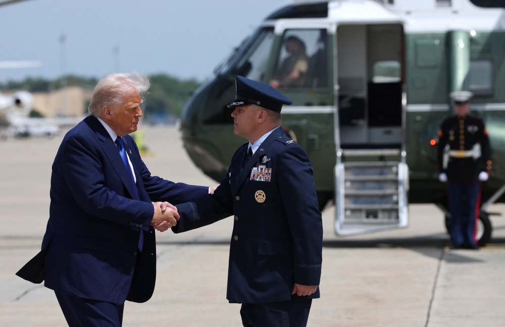 US President Donald Trump is greeted by Air Force Col. Paul R. Pawluk as he arrives to board Air Force One on May 12, 2025, at Joint Base Andrews, Maryland. Win McNamee/Getty Images/AFP 