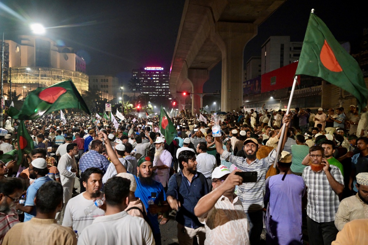 Bangladeshis wave national flags as they celebrate after the interim government officially banned all activities of the Awami League (AL) under the Anti-Terrorism Act, pending the conclusion of the International Crimes Tribunal (ICT) trials against the party and its leaders, in Dhaka on May 10, 2025. (Photo by MUNIR UZ ZAMAN / AFP)
