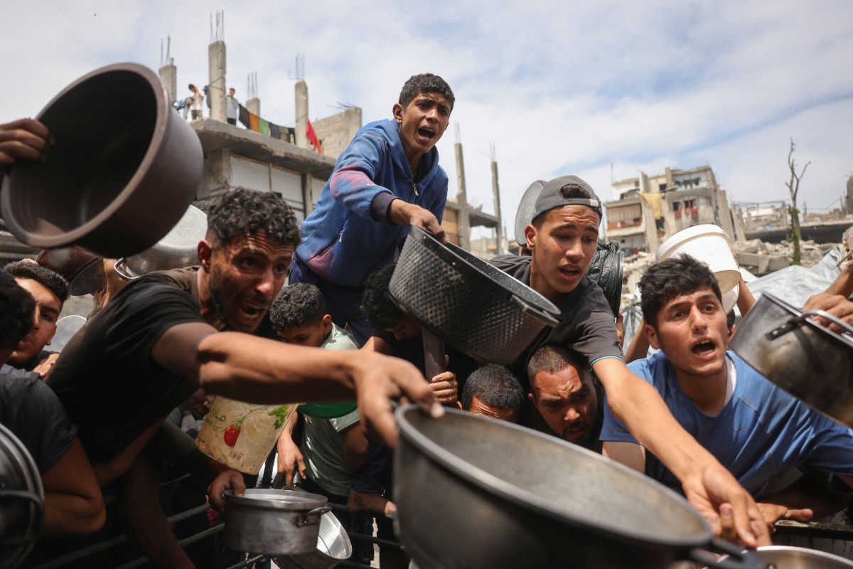 Palestinians struggle to get their food rations ouside a crowded distribution centre in Beit Lahia in the northern Gaza Strip on May 15, 2025. Photo by BASHAR TALEB / AFP.
