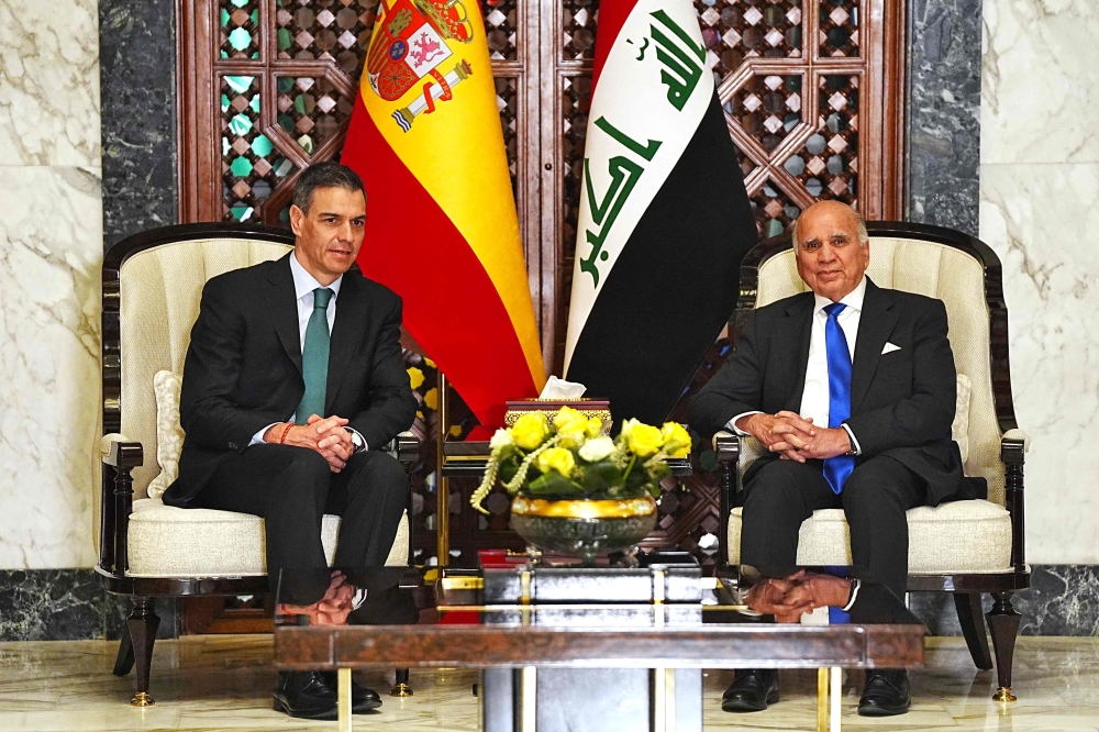 Iraq's Foreign Minister Fuad Hussein (R) meets with Spanish Prime Minister Pedro Sanchez ahead of the 34th Arab League summit in Baghdad on May 16, 2025. (Photo by Murtada Al-Sudani / Pool / AFP)