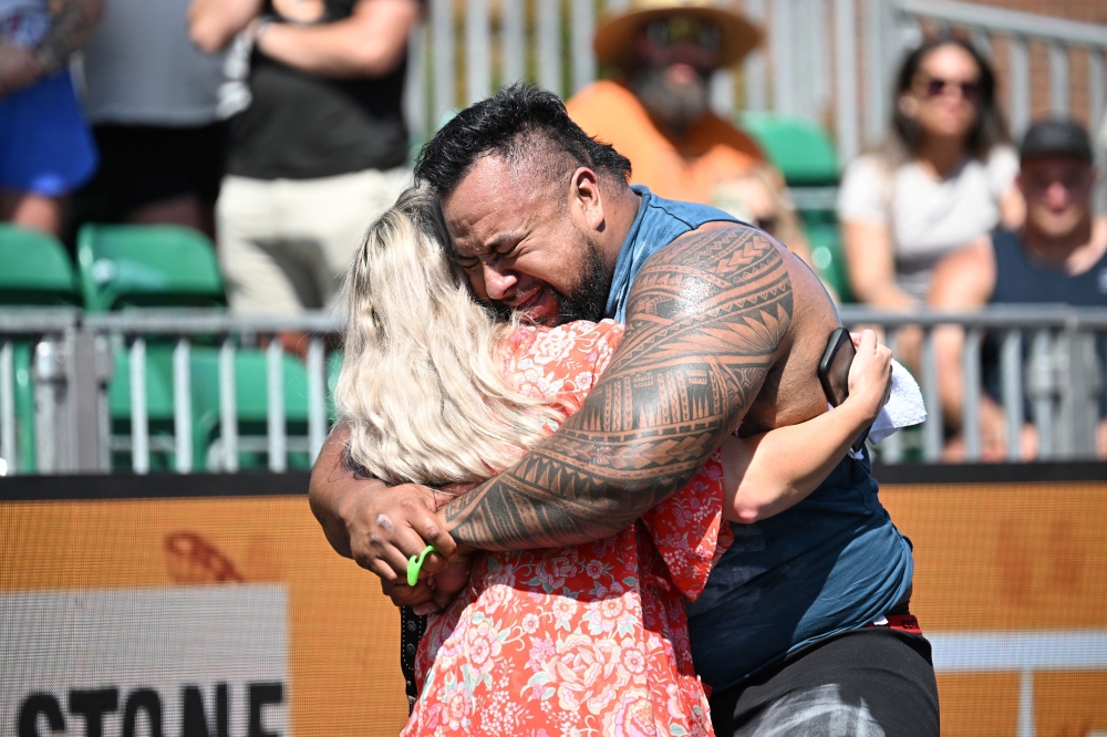 Eddie Williams of Australia hugs his wife after competing in the Natural Stone Medley during the qualifying round at the 
