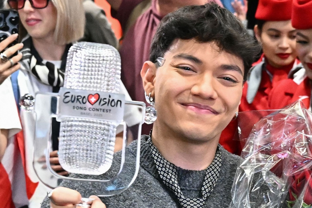 Austrian singer Johannes Pietsch aka JJ, winner of the 2025 Eurovision Song Contest, holds up the trophy as he arrives at Vienna International Airport in Schwechat, Austria on May 18, 2025. (Photo by Joe Klamar / AFP) /