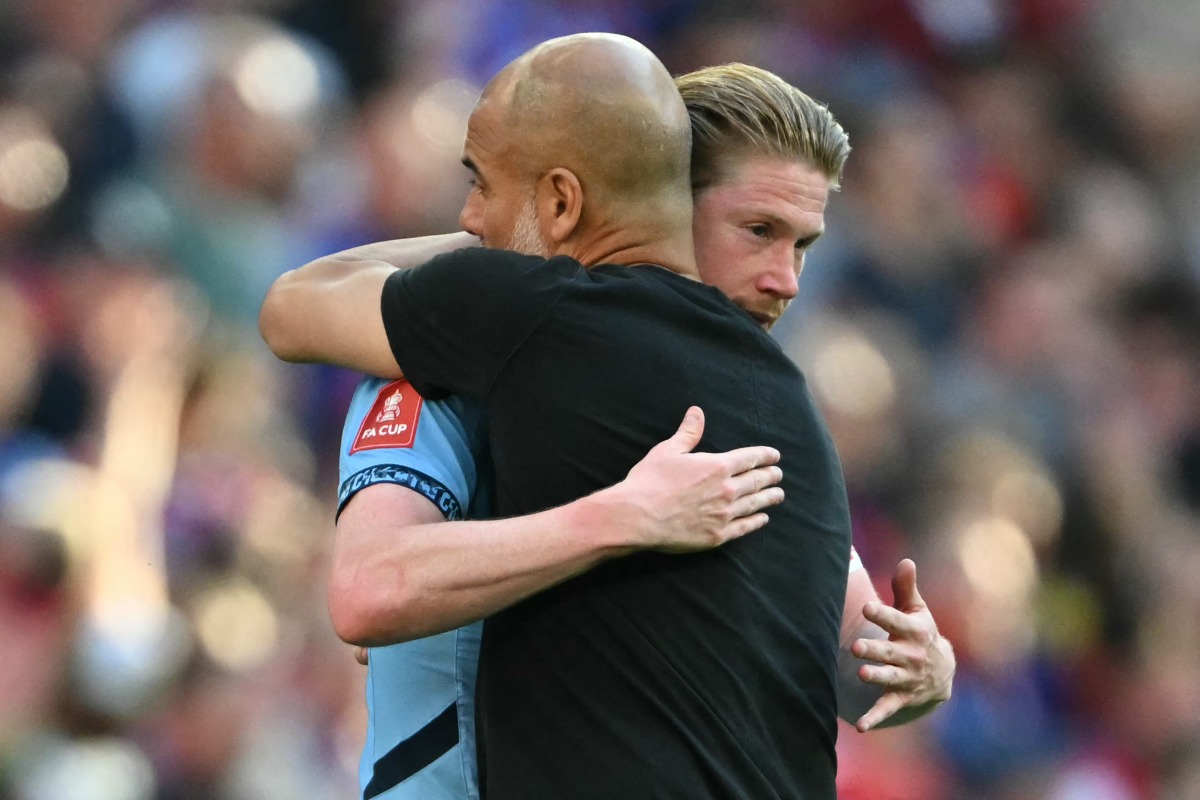 Manchester City's Spanish manager Pep Guardiola (R) embraces Manchester City's Belgian midfielder #17 Kevin De Bruyne (L) on the pitch after the English FA Cup final football match between Crystal Palace and Manchester City at Wembley stadium in London, on May 17, 2025. (Photo by Glyn KIRK / AFP)