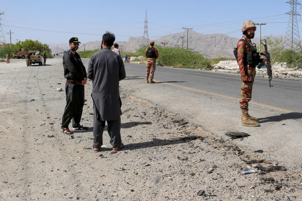 Security personnel stand guard at the site of a school bus bombing in Khuzdar district of Balochistan province on May 21, 2025. (Photo by AFP)