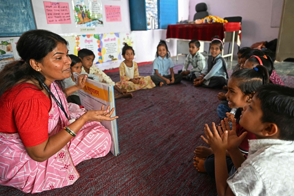 In this photograph taken on April 8, 2025, teacher Jashoda Khokariya teaches students inside the classroom at Kalyanpur village. (Photo by Money Sharma / AFP) 