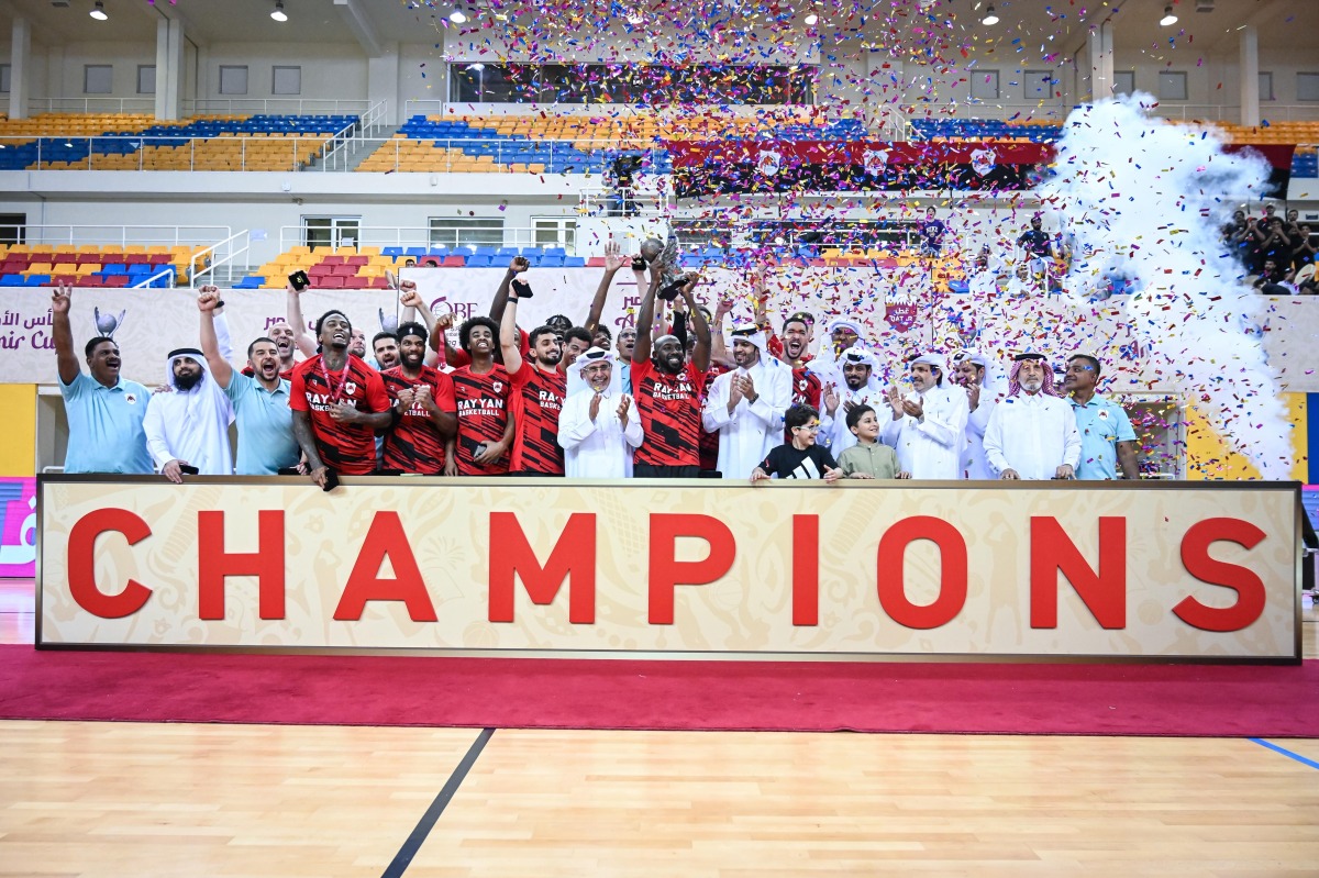 Al Rayyan players and officials celebrate with the trophy.