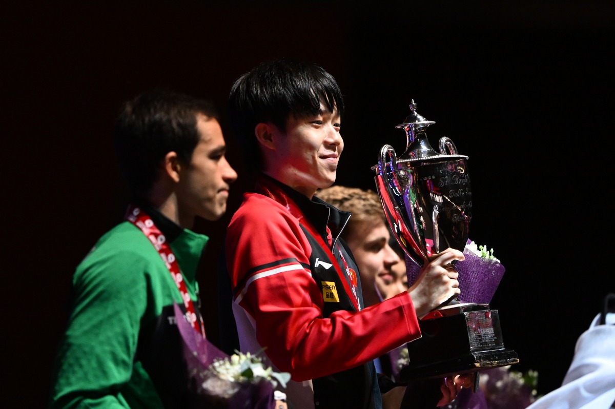 Men's singles champion Wang Chuqin (centre) of China with the podium winners during the presentation ceremony. (Photo by XHINHUA)