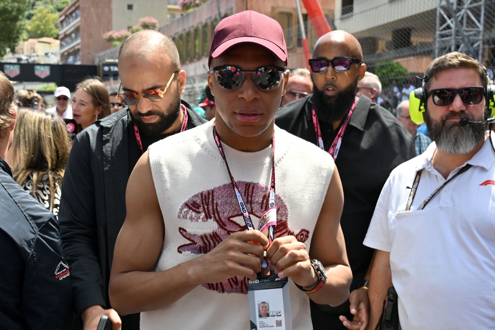 French footballer Kylian Mbappe (C) arrives at the track ahead of the Formula One Monaco Grand Prix at the Circuit de Monaco, on May 25, 2025. (Photo by Andrej Isakovic / AFP)