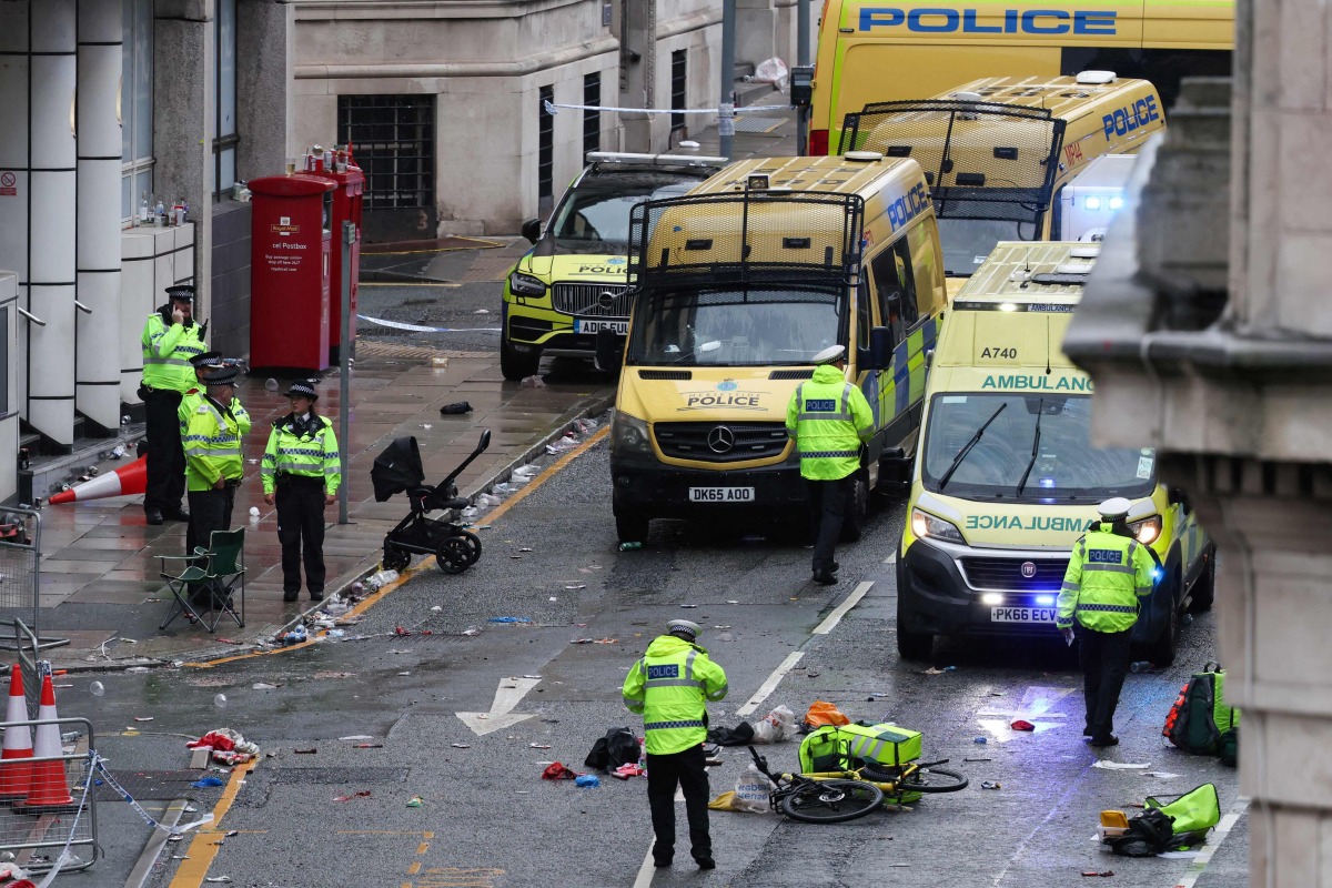 Police officers investigate the scene of an incident in Water Street, on the sidelines of an open-top bus victory parade for Liverpool's Premier League title win, in Liverpool, north-west England on May 26, 2025. (Photo by Darren Staples / AFP)
