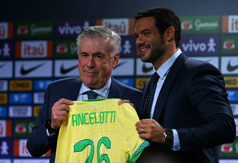 Brazil's football team new head coach, Italian Carlo Ancelotti (left) receives the team's jersey from the president of the Brazilian Football Confederation (CBF) Samir Xaud during his official presentation at a hotel in Barra da Tijuca neighbourhood, Rio de Janeiro, Brazil, on May 26, 2025. (Photo by Mauro Pimentel / AFP)
