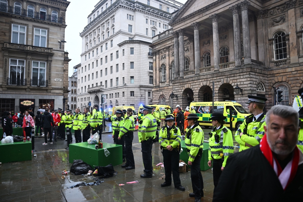 Police officers stand guard in front of the Liverpool Town Hall following an incident in Water Street (rear) on May 26, 2025. (Photo by Paul Ellis / AFP)