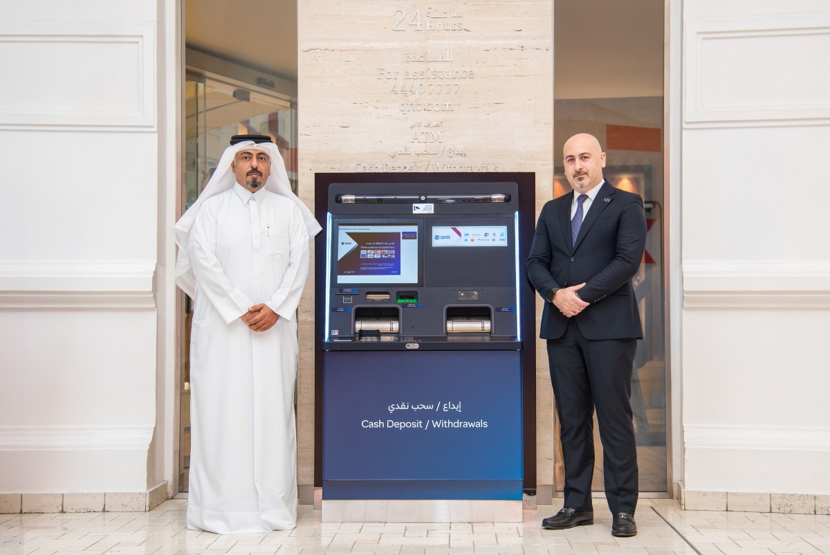 QNB officials pose for a photo with the Bulk Cash Deposit ATM machine.