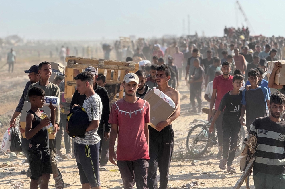 Displaced Palestinians receive food packages from a US-backed foundation pledging to distribute humanitarian aid in western Rafah in the southern Gaza Strip on May 27, 2025. (Photo by AFP)