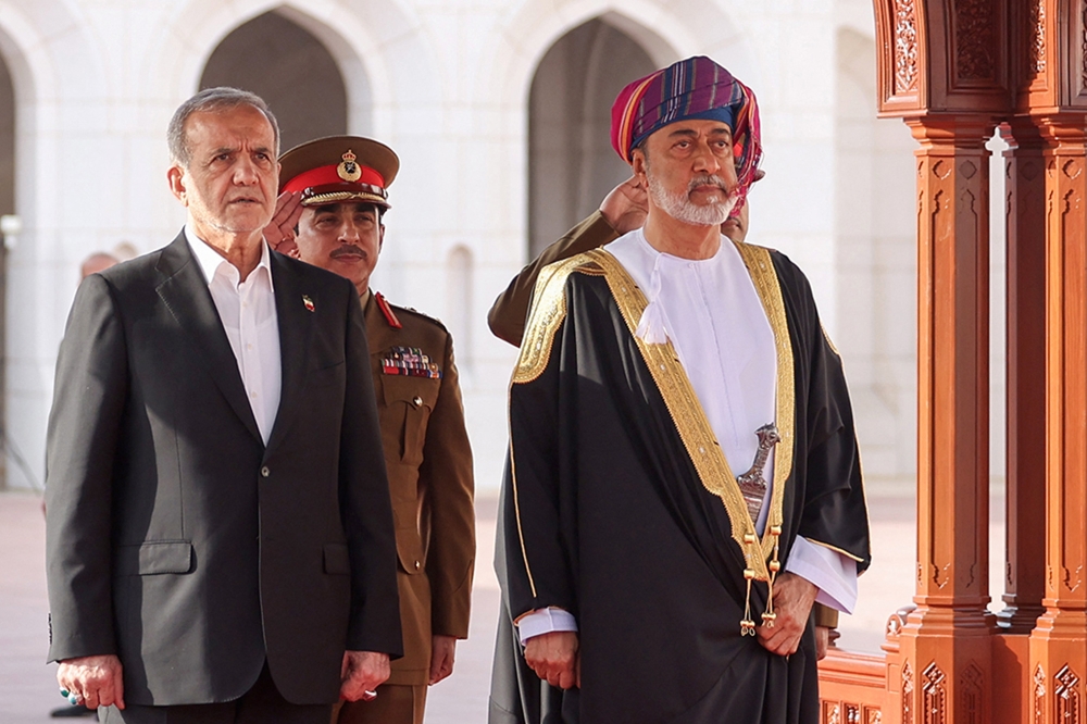 This handout picture provided by the Iranian presidential office shows Oman's Sultan Haitham bin Tariq al-Said (R) receiving Iran's President Masoud Pezeshkian (L) in Muscat on May 27, 2025. (Photo by Iranian Presidency / AFP)