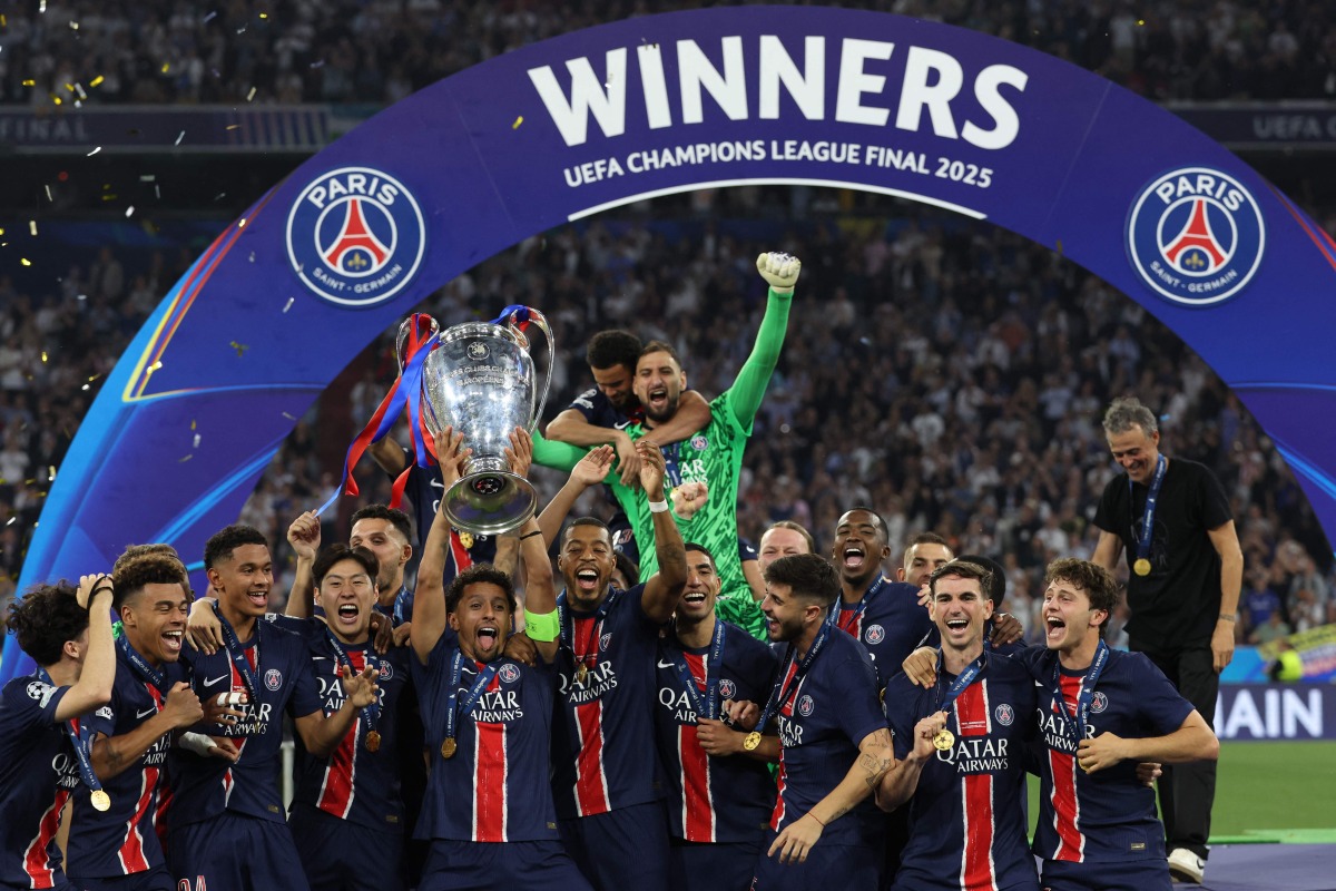 Paris Saint-Germain's Brazilian defender #05 Marquinhos lifts the trophy as he celebrates with teammates winning the UEFA Champions League final football match between Paris Saint-Germain (PSG) and Inter Milan in Munich, southern Germany, on May 31, 2025. (Photo by FRANCK FIFE / AFP)