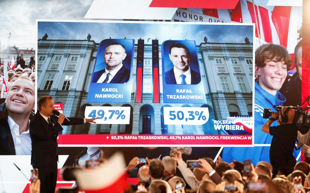 Preliminary results are displayed during the election night event showing the percentage of votes for presidential candidates, Karol Nawrocki and Rafal Trzaskowski, at the Mala Warszawa Theatre in Warsaw, Poland, on June 1, 2025. (Photo by Wojtek Radwanski / AFP)