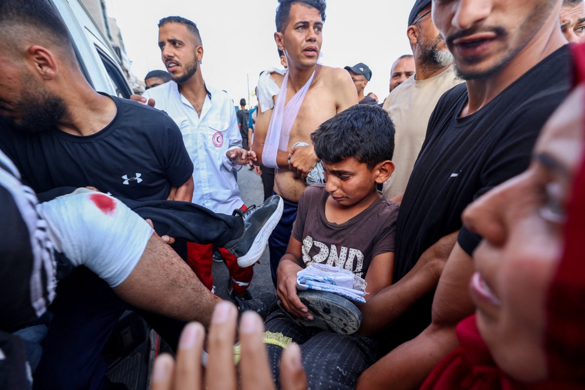 Palestinian rescuers evacuate injured people in an ambulance after an Israeli drone reportedly opened fire on civilian gatherings near an aid distribution point not far from the so-called 