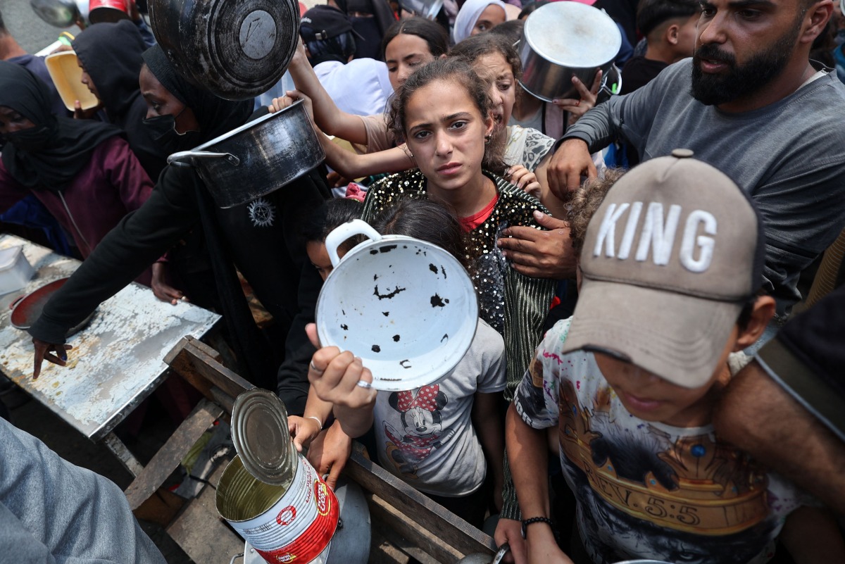  Palestinian children gather at a hot meal distribution point in Nuseirat in the central Gaza Strip, June 4, 2025. (Photo by Eyad BABA / AFP)
