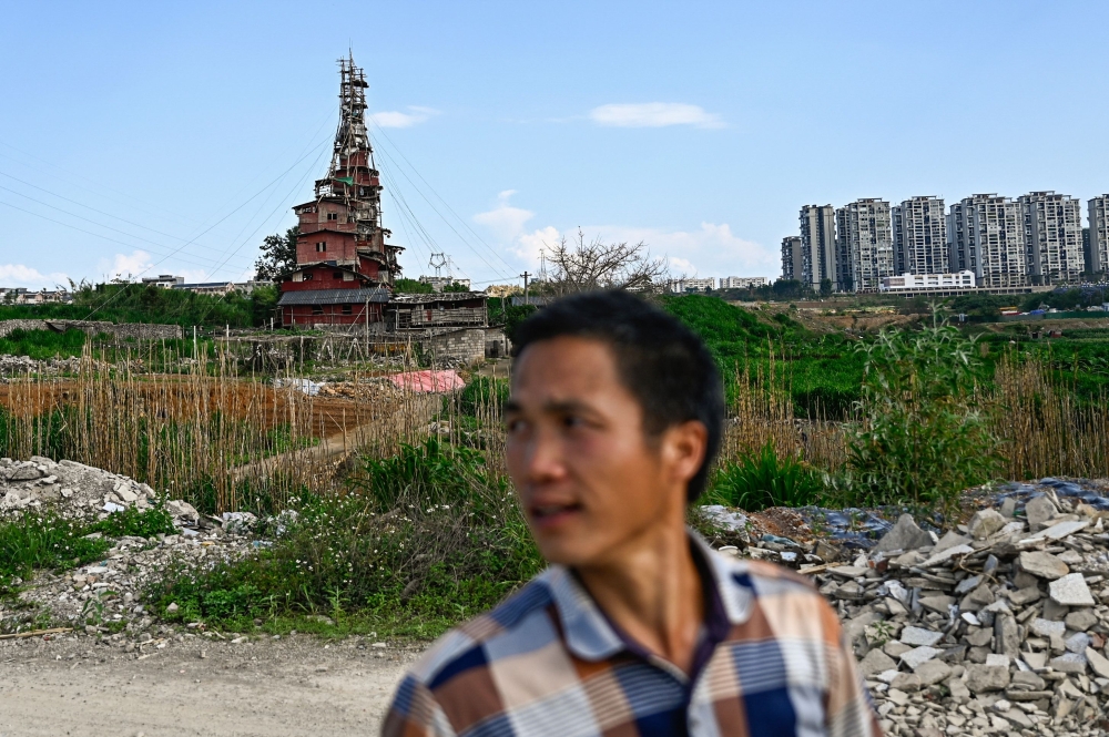 This picture taken on May 20, 2025 shows Chen Tianming standing near his house labelled China's strangest 