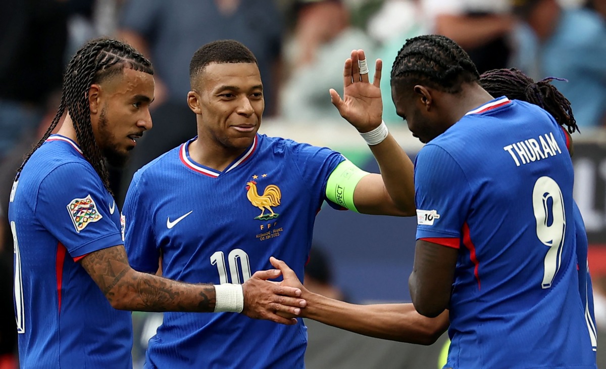 France's forward #11 Michael Olise (R, hidden) is congratulated by (L-R) France's defender #17 Malo Gusto, France's forward #10 Kylian Mbappe and France's forward #09 Marcus Thuram after scoring the 0-2 goal during the UEFA Nations League third place play-off football match between Germany and France in Stuttgart, southwestern Germany on June 8, 2025. (Photo by FRANCK FIFE / AFP)
