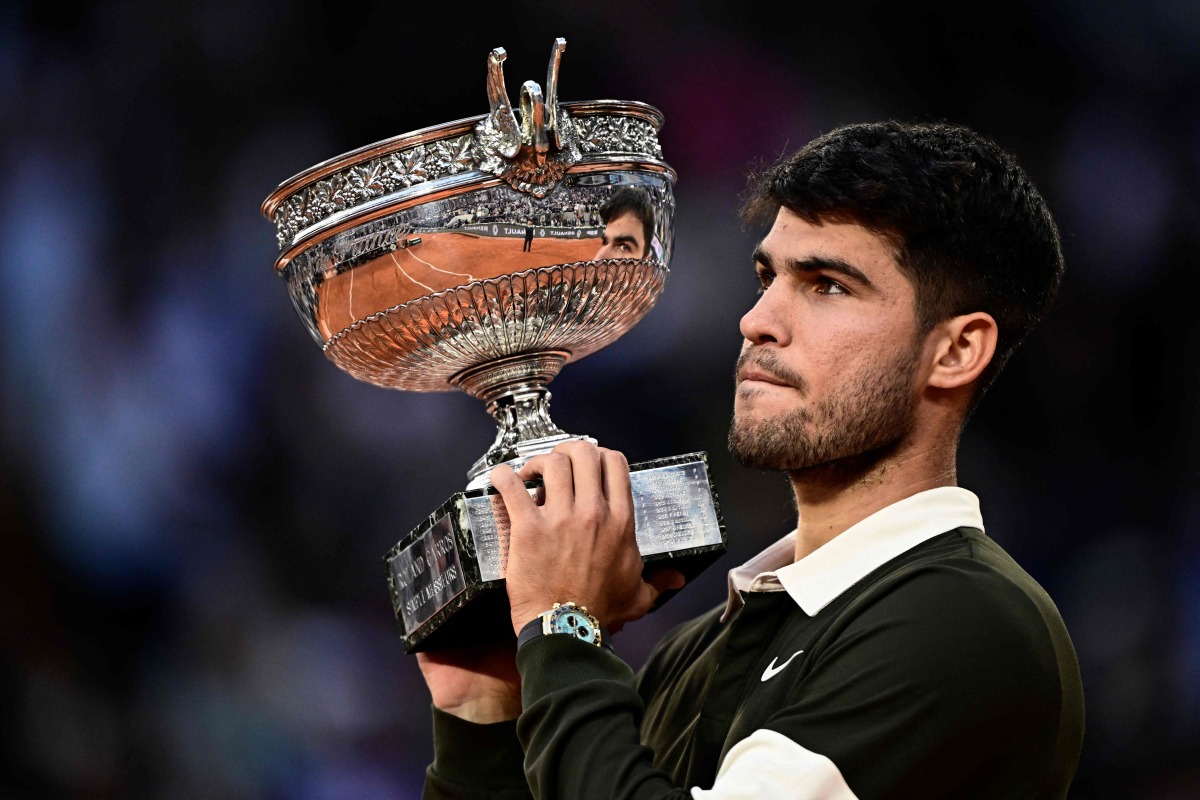 Spain's Carlos Alcaraz holds the trophy after winning the men's singles final match against Italy's Jannik Sinner on day 15 of the French Open tennis tournament on Court Philippe-Chatrier at the Roland-Garros Complex in Paris on June 8, 2025. (Photo by JULIEN DE ROSA / AFP)